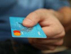 Blaue DEBIT-Card wird vom Käufer gereicht